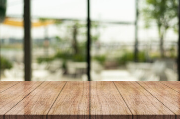 Empty wooden table top with lights bokeh on blur restaurant background.