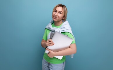 blond confident business lady in a casual look with a laptop in her hands on a blue background
