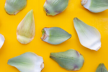 Fresh artichoke petals on yellow background