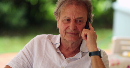 Older man talking on the phone. Candid authentic real life senior person talking on smartphone