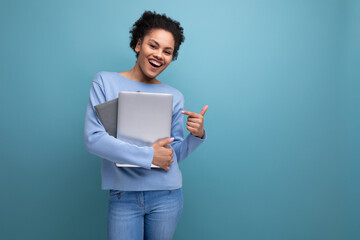 successful young afro brunette female student with a laptop and documents in her hands