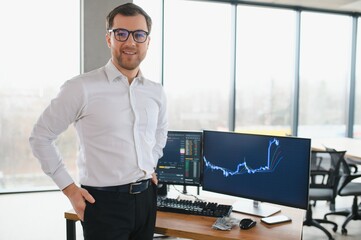 Serious business man trader analyst looking at computer monitor, investor broker analyzing indexes,...
