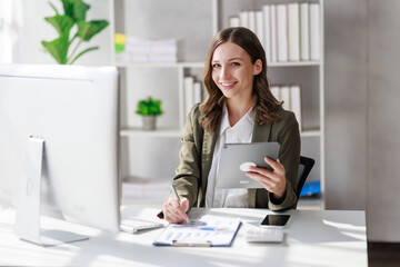 Concept of business office woman working,Businesswoman smile while working about her invesment plan with analyzing document and business investment graph data by using laptop on desk in workstation.