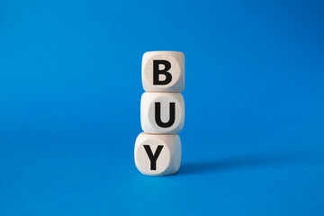 BUY symbol. Concept word BUY on wooden blocks. Beautiful blue background. Business and BUY concept. Copy space