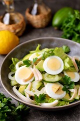 Salad with squid, avocado, cucumber, lettuce and egg with olive oil and lemon juice