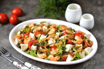 Salad with shrimps, mozzarella, cherry tomatoes, lettuce, olive oil, lemon juice and mustard