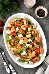Salad with shrimps, mozzarella, cherry tomatoes, lettuce, olive oil, lemon juice and mustard