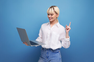 portrait of successful young pretty blond business woman in white blouse working using laptop....
