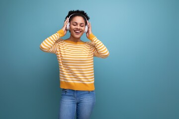 energetic afro brunette 20s latin young woman dancing to music with headphones