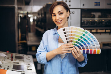 Woman working in printing house holding swatch palette