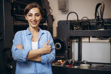 Woman working in printing house with paper and paints