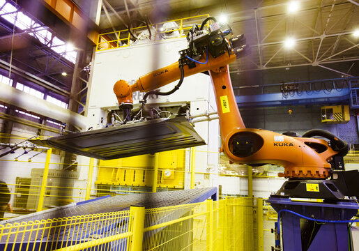Nizhny Novgorod, Russia - November 21, 2020: GAZ car production plant automatic pressing line. Kuka robot manipulator take metal car panel to stamping press