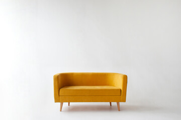 soft empty yellow sofa stands on white isolated background, comfortable fabric couch is alone against the white wall © Богдан Маліцький