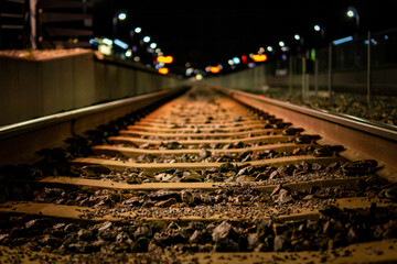 Railway train tracks with soft background at nighttime.