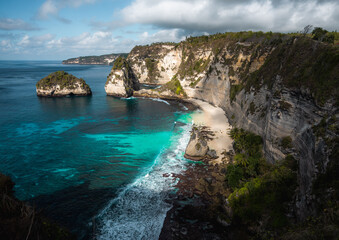Fototapeta na wymiar Stunning view of the Diamond Beach bathed by a turquoise sea during a beautiful sunrise. Diamond Beach is an untouched, white-sand and silky blue water bay on the eastern tip of Nusa Penida.