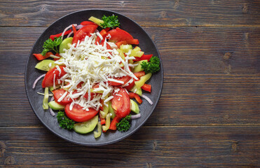 Balkan cuisine. Shopska Salad, traditional dish of the Balkan. It is made from vegetables and cheese. Dark rustic table. Copy space