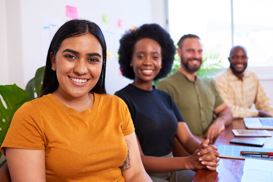 Portrait of beautiful Indian woman, diverse colleagues boardroom table in a row