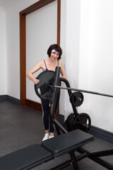 Fototapeta premium Woman athlete hangs a weight barbell.