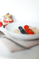 Oatmeal with berries vertical photo. Healthy breakfast, diet, weight loss