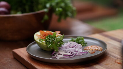 Tropical salad with avocado, tomato, red onion and cilantro. Light food for summer.
