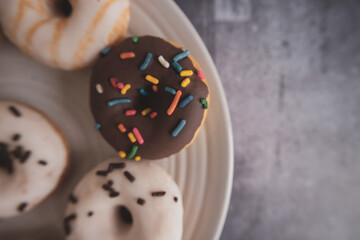 Donuts. Top view. Colorful donuts with icing as background . Colorful glazed doughnuts with sprinkles.