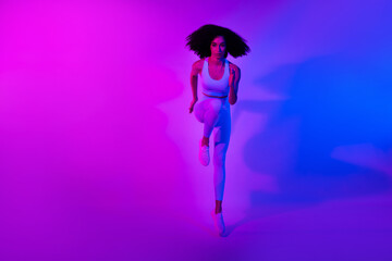 Full length photo of running marathon athlete sportswoman serious face advert clothes for gym isolated on neon colorful filter background