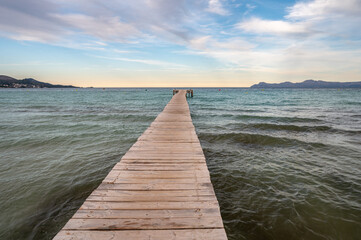 Obraz na płótnie Canvas A long wooden deck in Muro Beach. the longest sandy beach in Majorca Island.