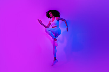 Full body photo of sporty fitness blogger jumping intense dynamic workout isolated on ultraviolet color neon background
