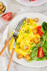 American scramble omelet with arugula, tomatoes and mushrooms. Breakfast