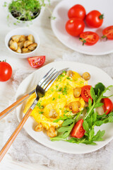 American scramble omelet with arugula, tomatoes and mushrooms. Breakfast