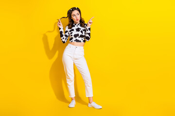 Full length photo of amazed girl in black spot garment pointing empty space milk product ads isolated on shine color background