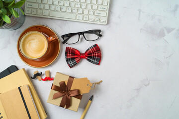 Happy Father's day concept with coffee cup, gift box and computer keyboard on office table. Top view from above