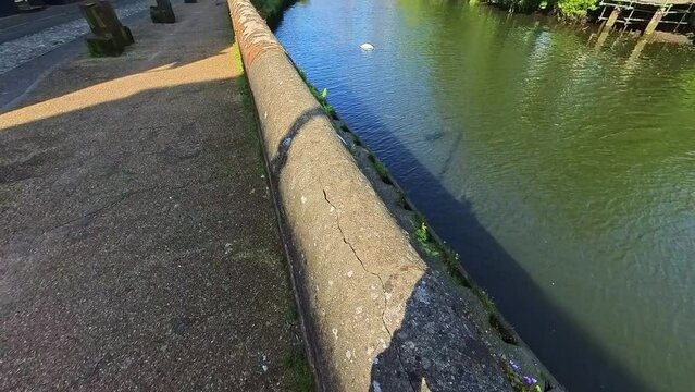 Reveal shot of the River Wensum, the historic Quayside and Fye Bridge in the city of Norwich. Captured on a bright and sunny morning