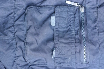 one long closed metal zip on a black gray cloth pocket on a garment