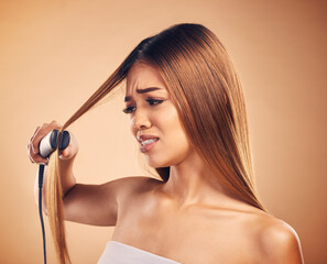 Woman with flat iron, hair care fail and worried about heat damage with hairloss isolated on studio...
