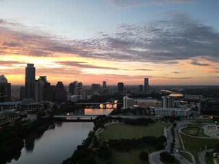 Downtown Austin Texas during early morning sunrise with orange red clouds in the horizon. 