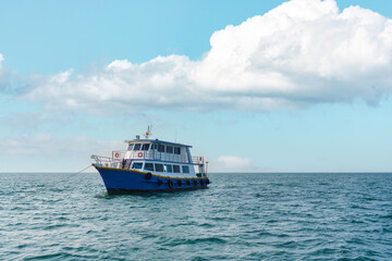 Obraz premium Ferry boat sailing on blue sea ripples