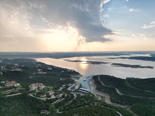 Aerial view of Lake Travis and the Texas Hill Country during a passing thunderstorm at sunset.