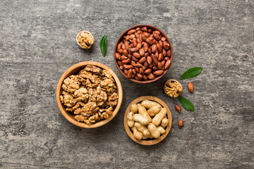 Walnut kernel halves with peanut, in a wooden bowl. Close-up, from above on colored background. Healthy eating groundnut concept. Super foods with copy space