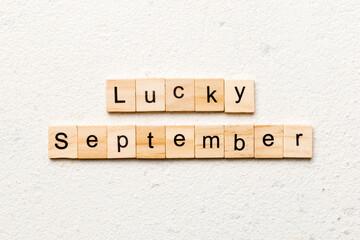 lucky september word written on wood block. lucky september text on table, concept
