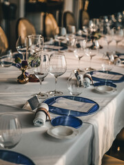Empty glasses and plates set for a luxury dinner in restaurant.