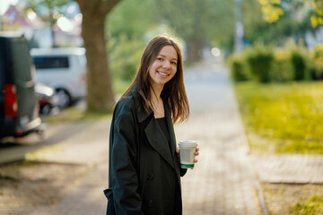 cheerful girl teenager with a paper cup of coffee