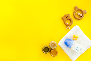 Feeding baby bottle with milk and kids accessories on table, top view. Childcare concept