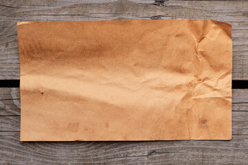 Old yellowed crumpled paper. Blank sheet of paper on vintage wooden back.
