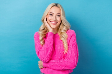 Photo of positive satisfied nice girl with wavy hairdo dressed pink sweater hold palm on cheekbone isolated on blue color background