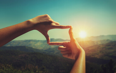 close up hand framing looking view sunrise.