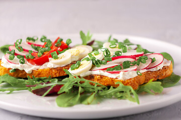 Toast with eggs, cheese, radishes and tomatoes. Light breakfast.