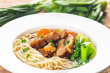 Spicy red soup beef noodle in a bowl on wooden table
