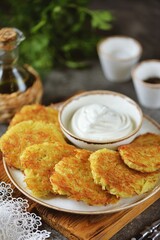 Potato pancakes with sour cream, fried in a pan in olive oil.