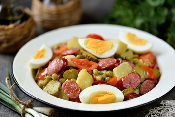 Salad of potatoes, pickled cucumbers, red onions, smoked sausages, tomatoes and boiled eggs.